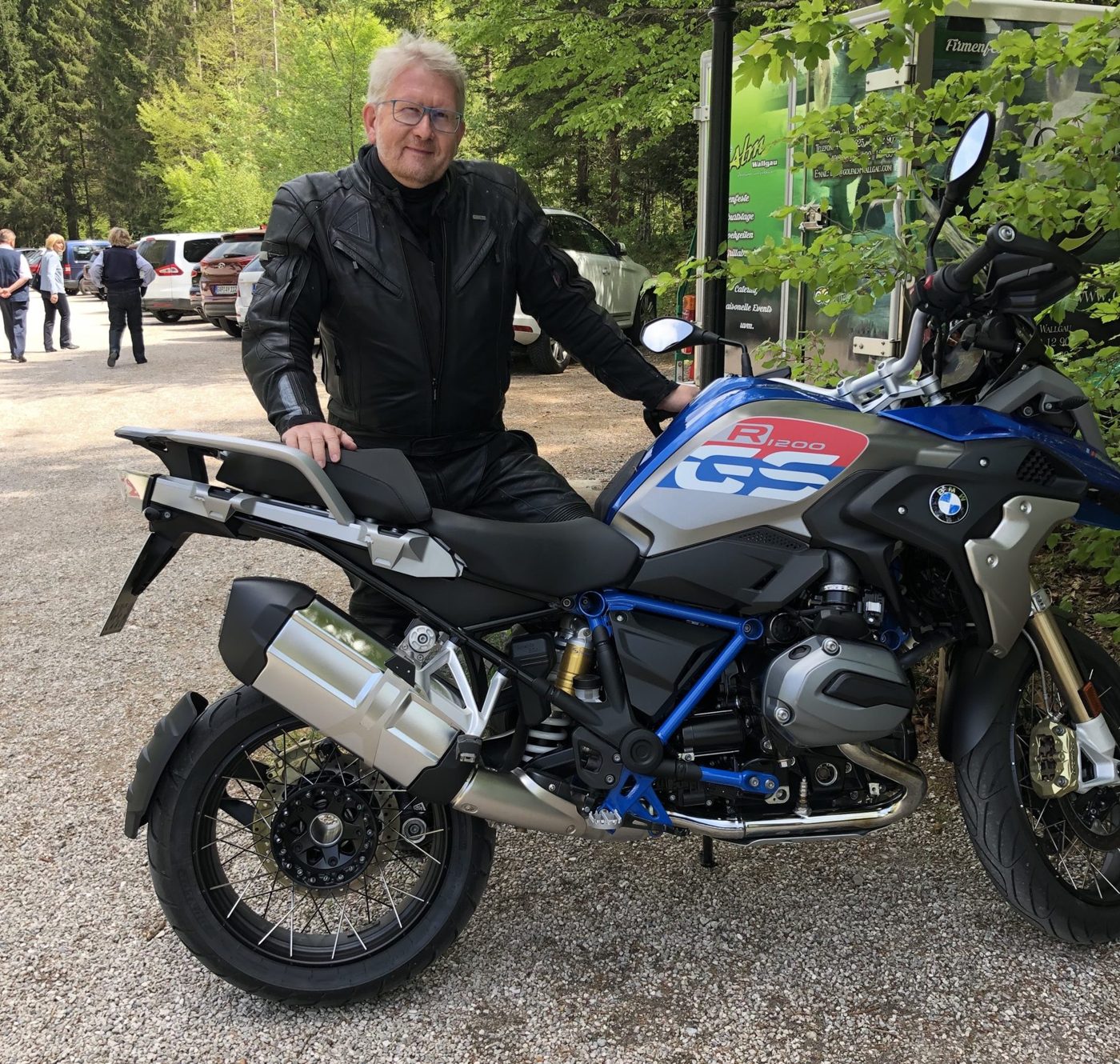 Detlef Gumze in Motorradkleidung neben seiner blauen BMW GS